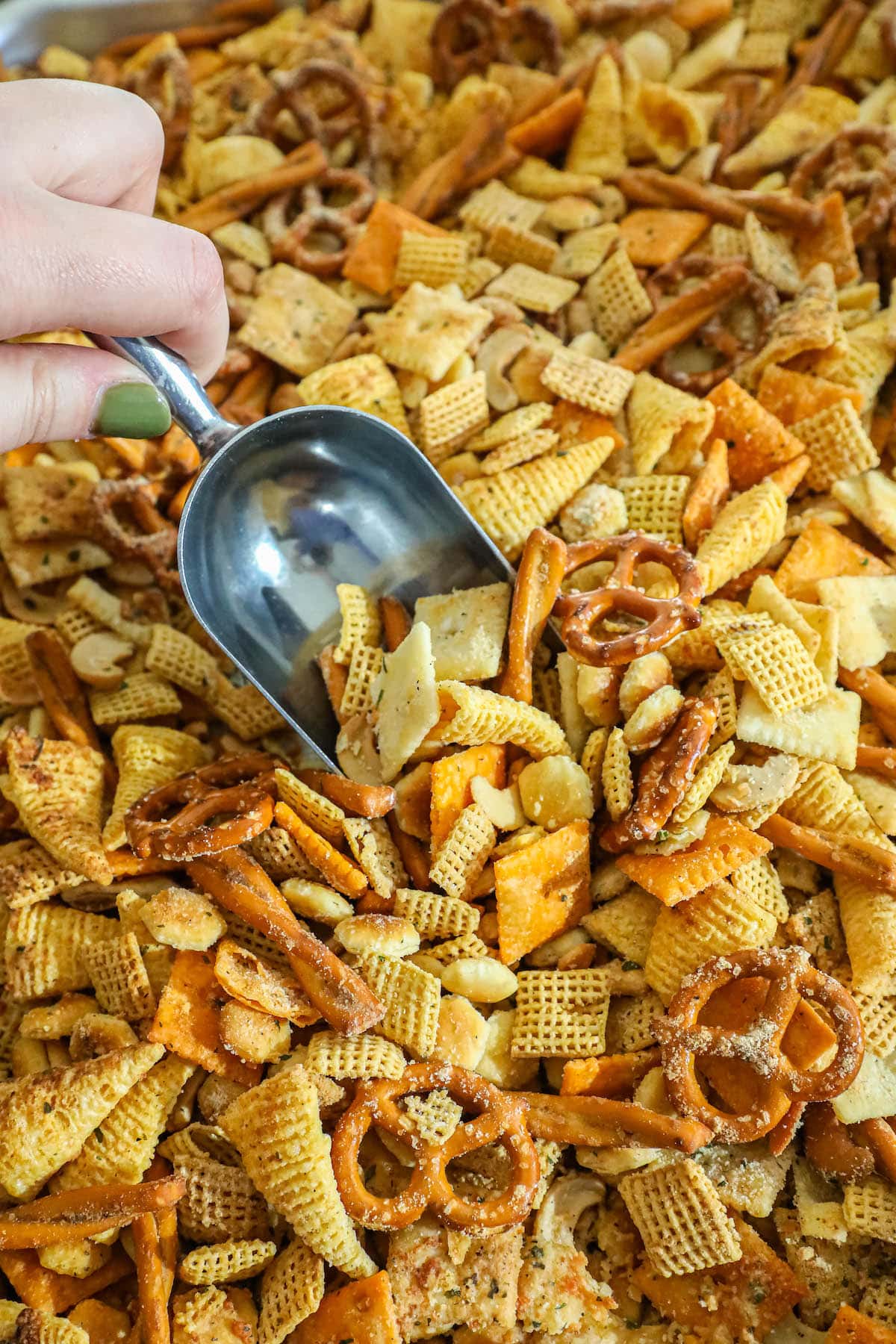 a hand scooping ranch seasoned chex mix 