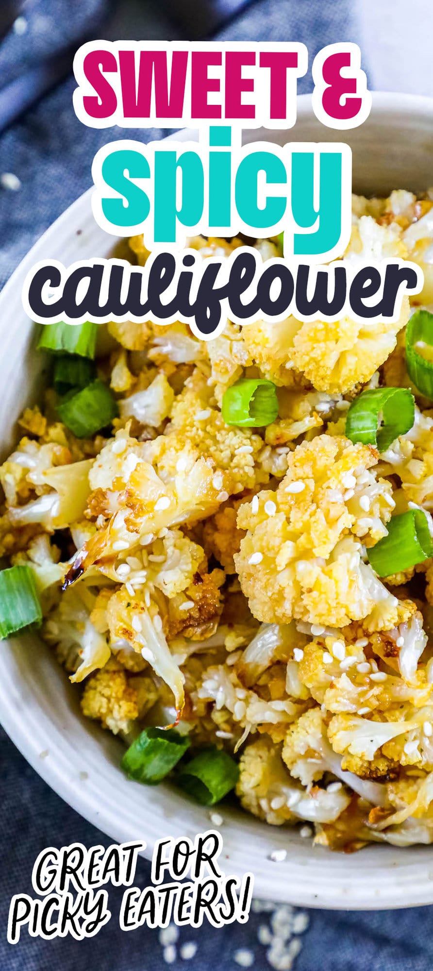 baked cauliflower with sesame seeds, sliced green onions, and seasoning in a white bowl on a table