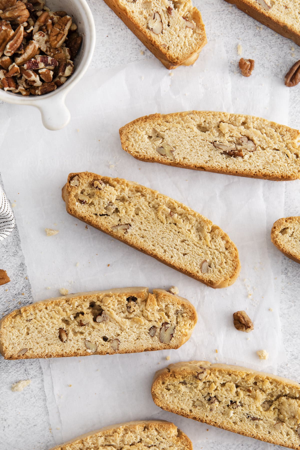 biscotti on a piece of parchment paper on a table with pecans 