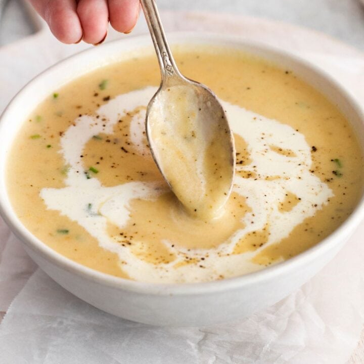 apple and cheddar soup in a bowl with a spoon