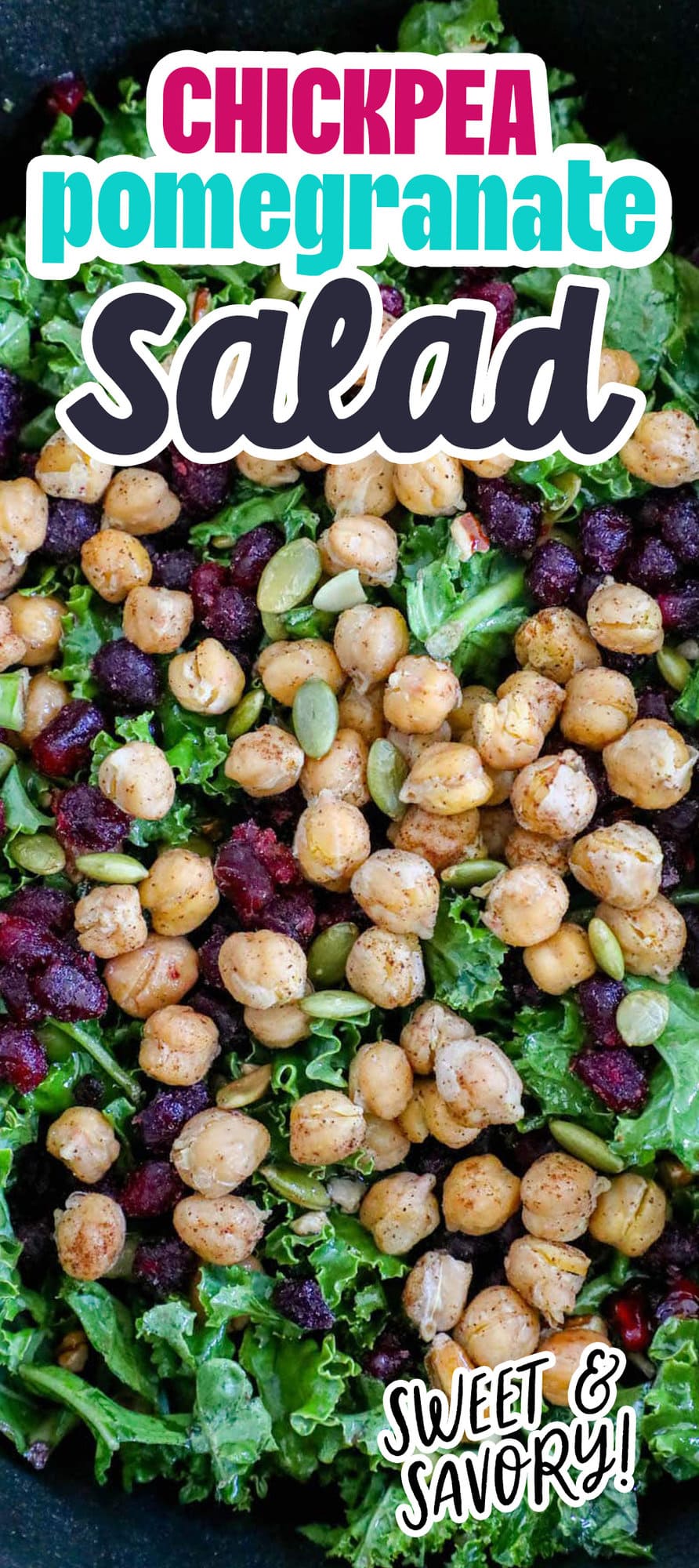 kale salad in a bowl with chickpeas, dried cranberries, pomegranate arils, pepitas, and dressing
