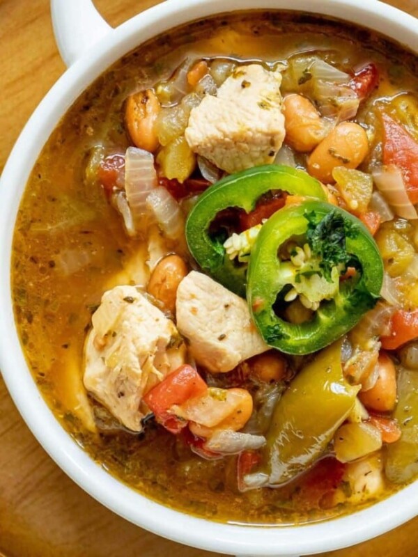 chicken stew with diced chicken breasts, tomatillos, onions, pinto beans, diced tomatoes, and sliced jalapeños on top