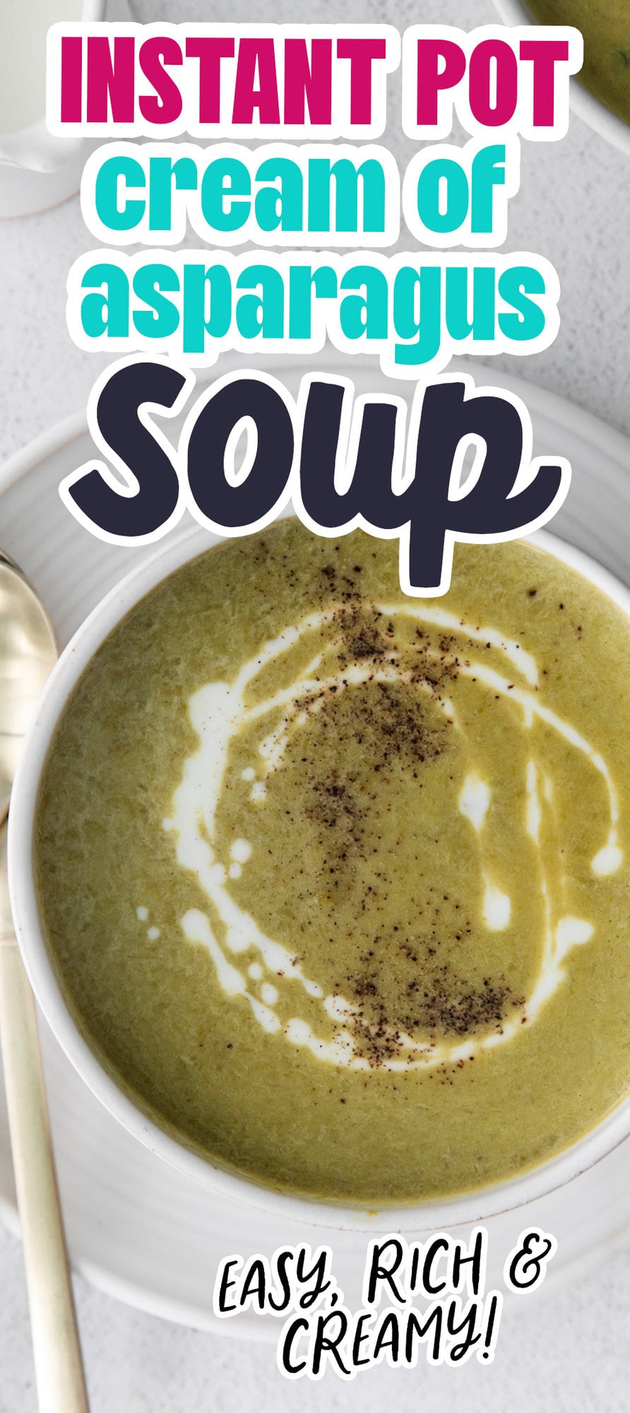 creamy asparagus soup in a white bowl with a swirl of cream on top and lots of fresh cracked pepper 