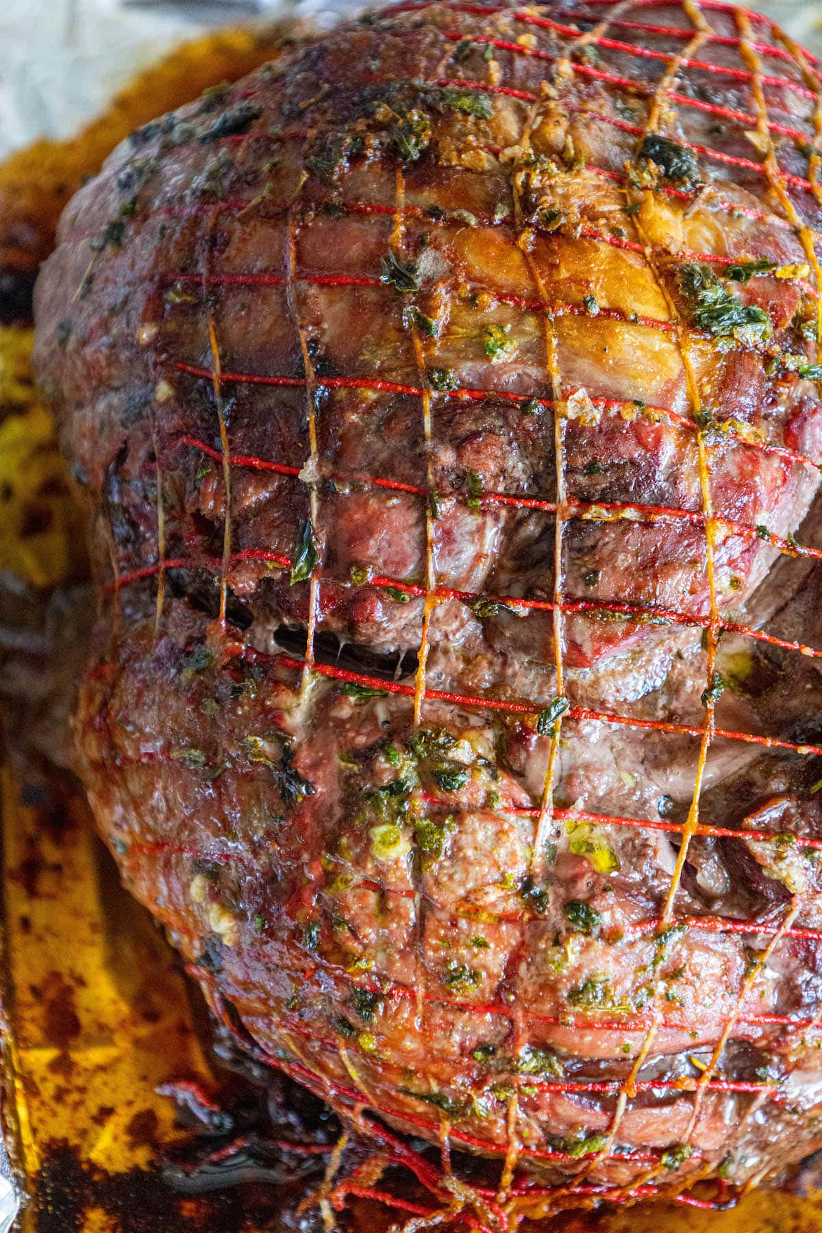 roasted leg of lamb in a baking tray lined with foil