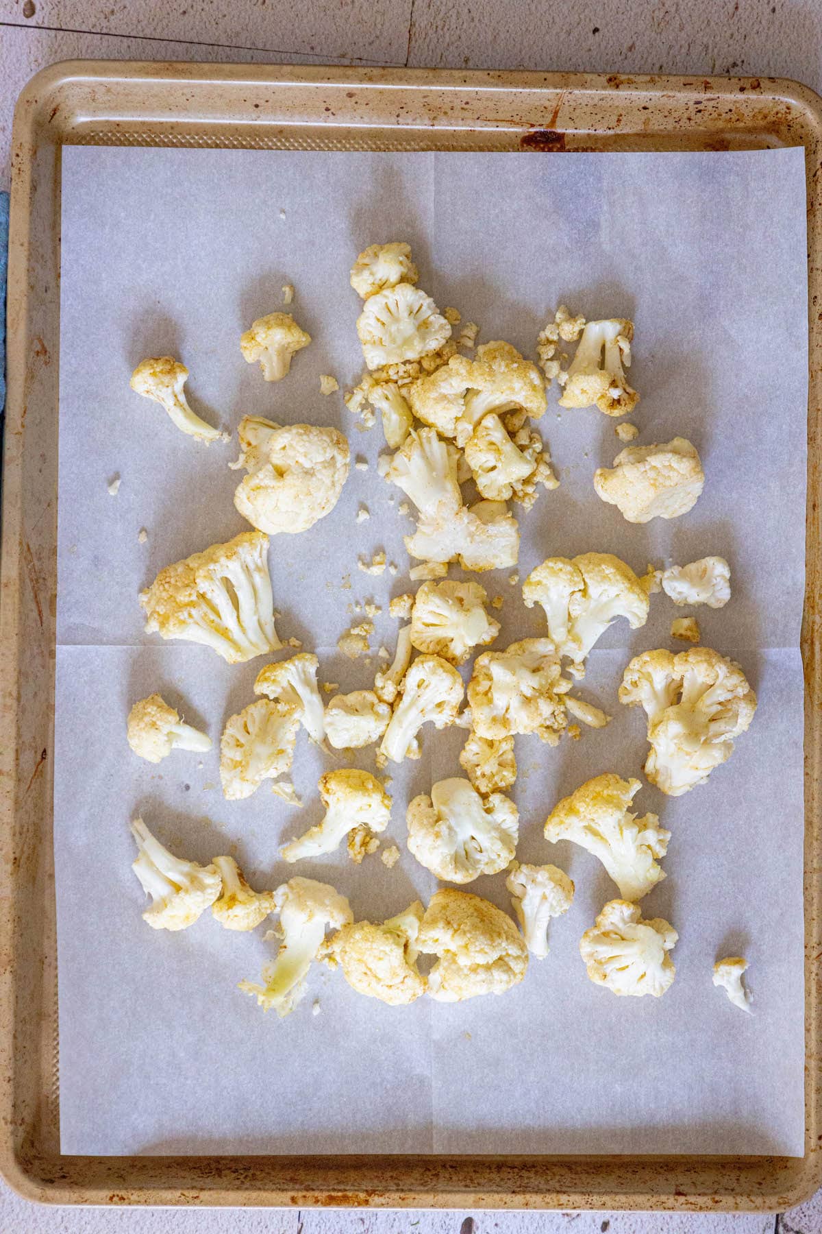 seasoned cauliflower on a baking sheet lined with parchment paper