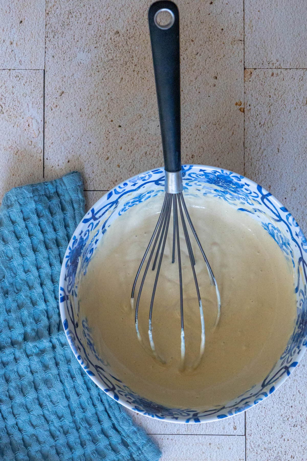 a whisk in a bowl whisking tahini sauce