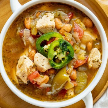 chicken stew with diced chicken breasts, tomatillos, onions, pinto beans, diced tomatoes, and sliced jalapeños on top