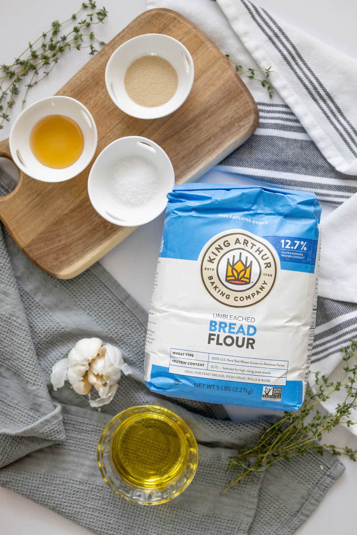 The overnight garlic herb focaccia ingredients are on a cutting board.