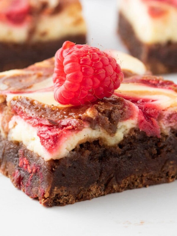 A slice of brownie with raspberries on top.