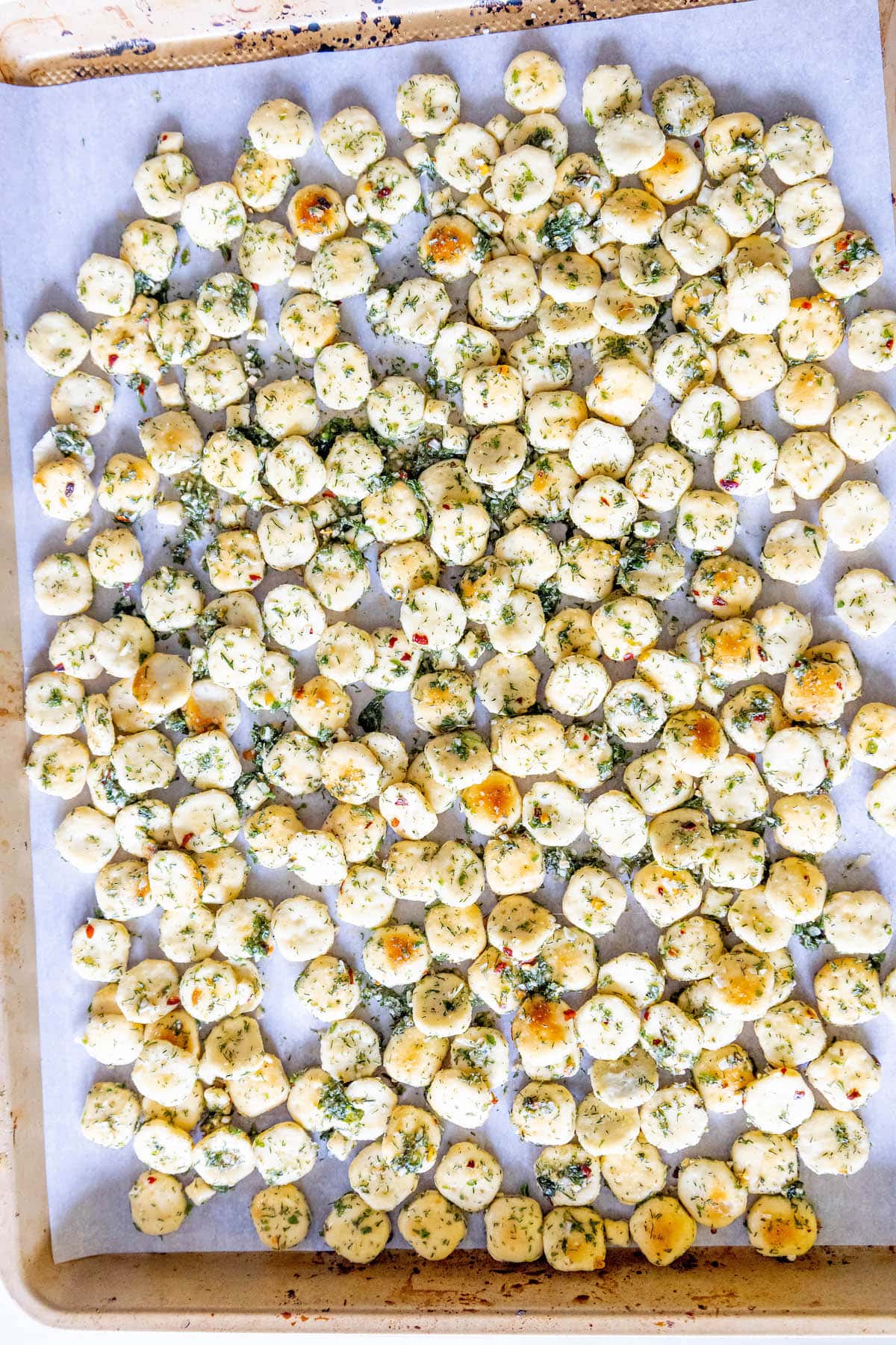 oyster crackers with seasoning on a baking sheet with parchment paper