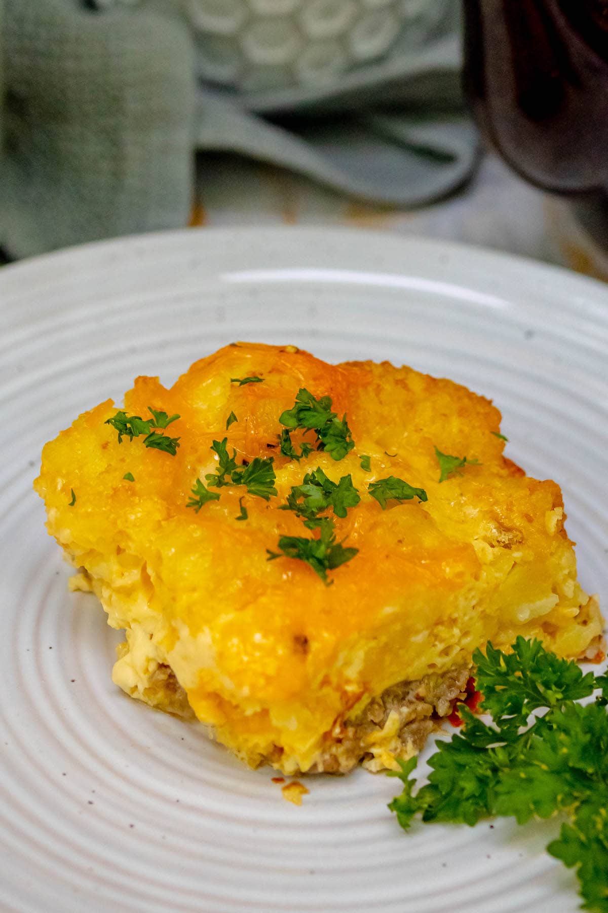 cheesy baked tater tot casserole on a white plate