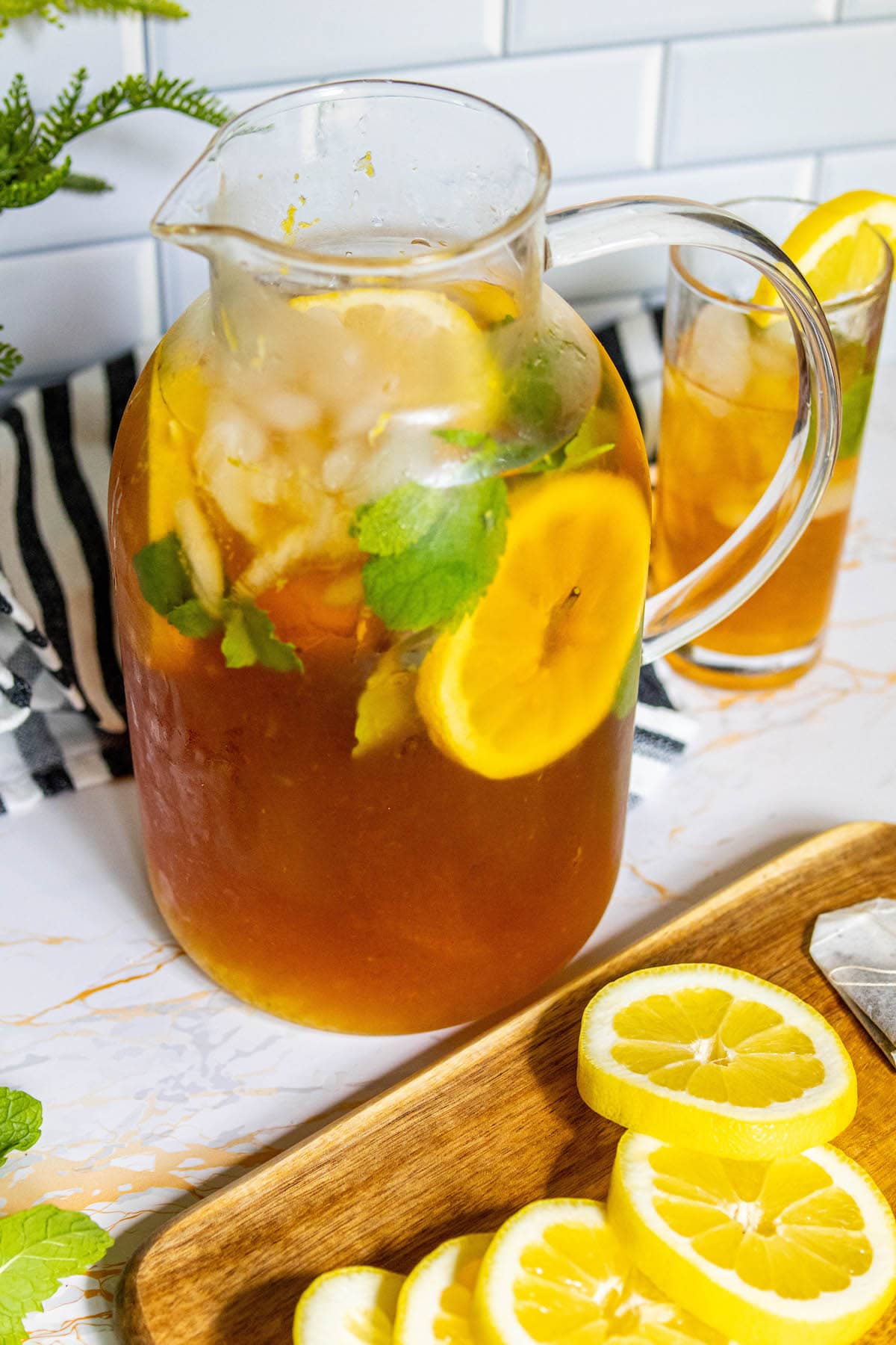 lemonade iced tea arnold palmer in a pitcher with sliced citrus and mint