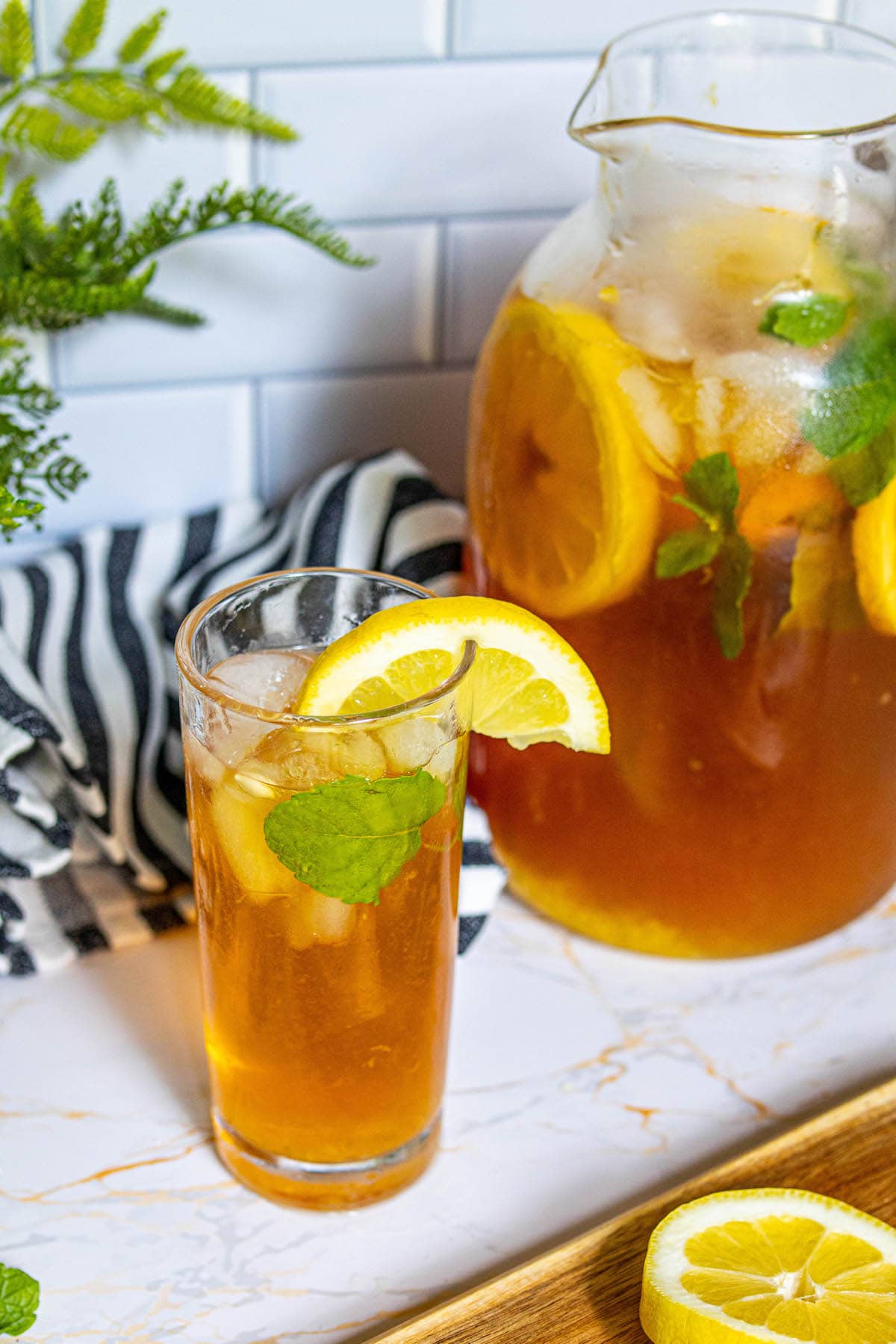 lemonade iced tea arnold palmer in a pitcher with sliced citrus and mint