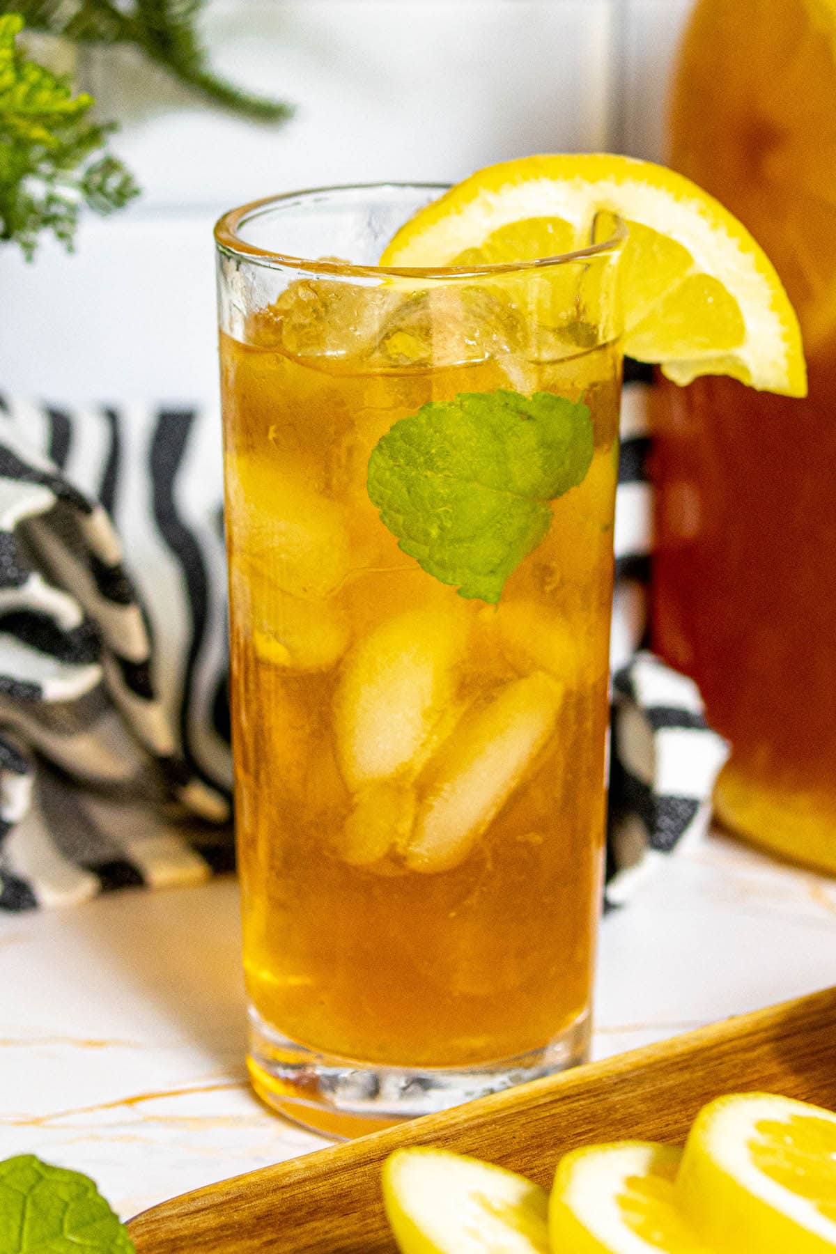 lemonade iced tea arnold palmer in a glass with sliced citrus and mint