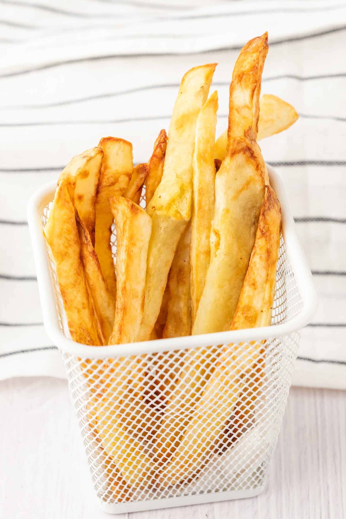 crispy air fried french fries in a white basket