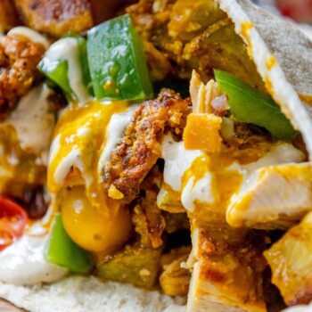 chicken shawarma pita with tahini and amba sauce on a table