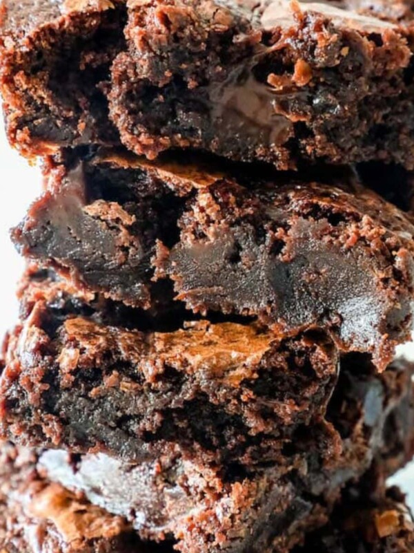 super chocolatey fudge brownies stacked on top of each other on a table