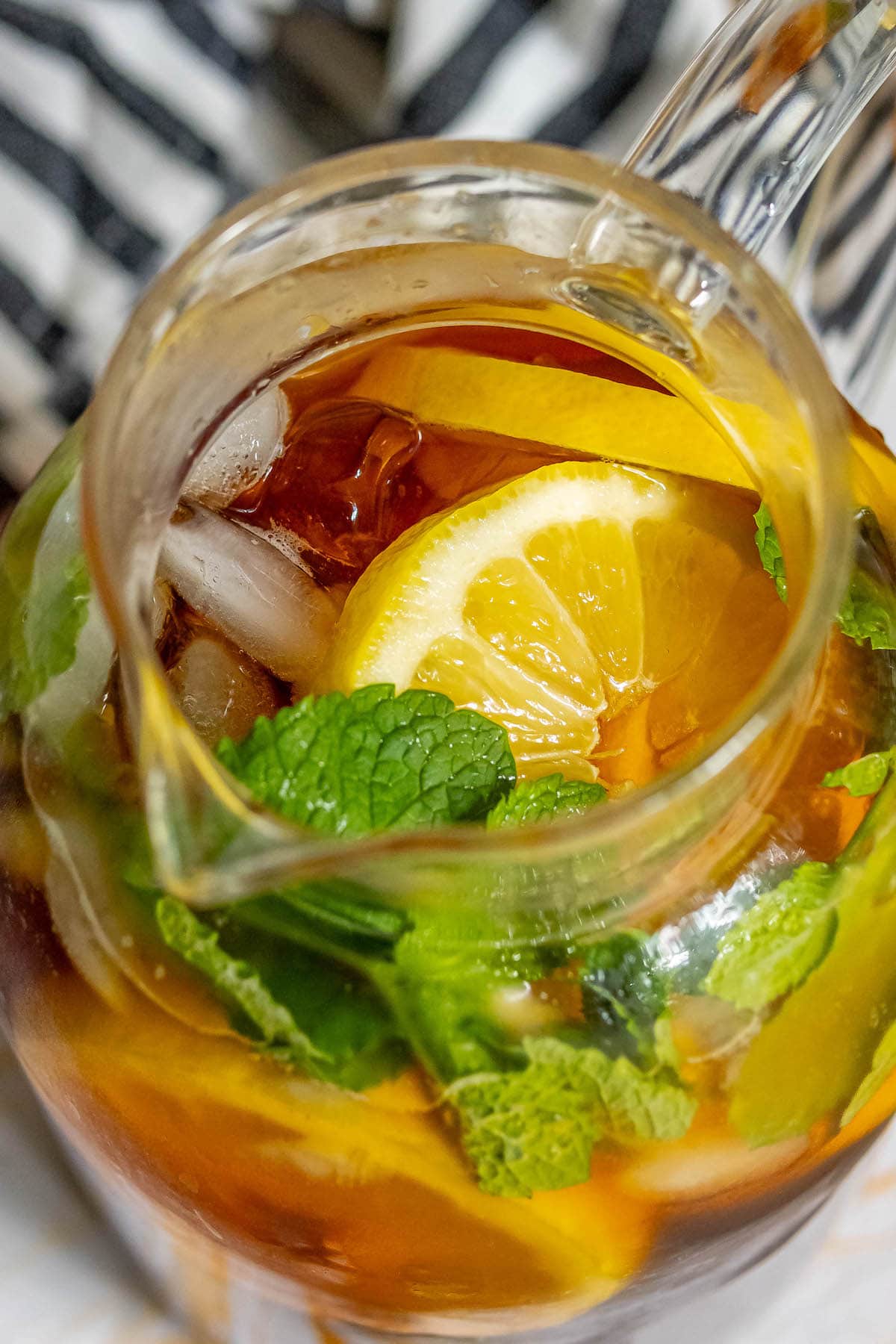 tea in a pitcher with sliced lemons, mint, and ice