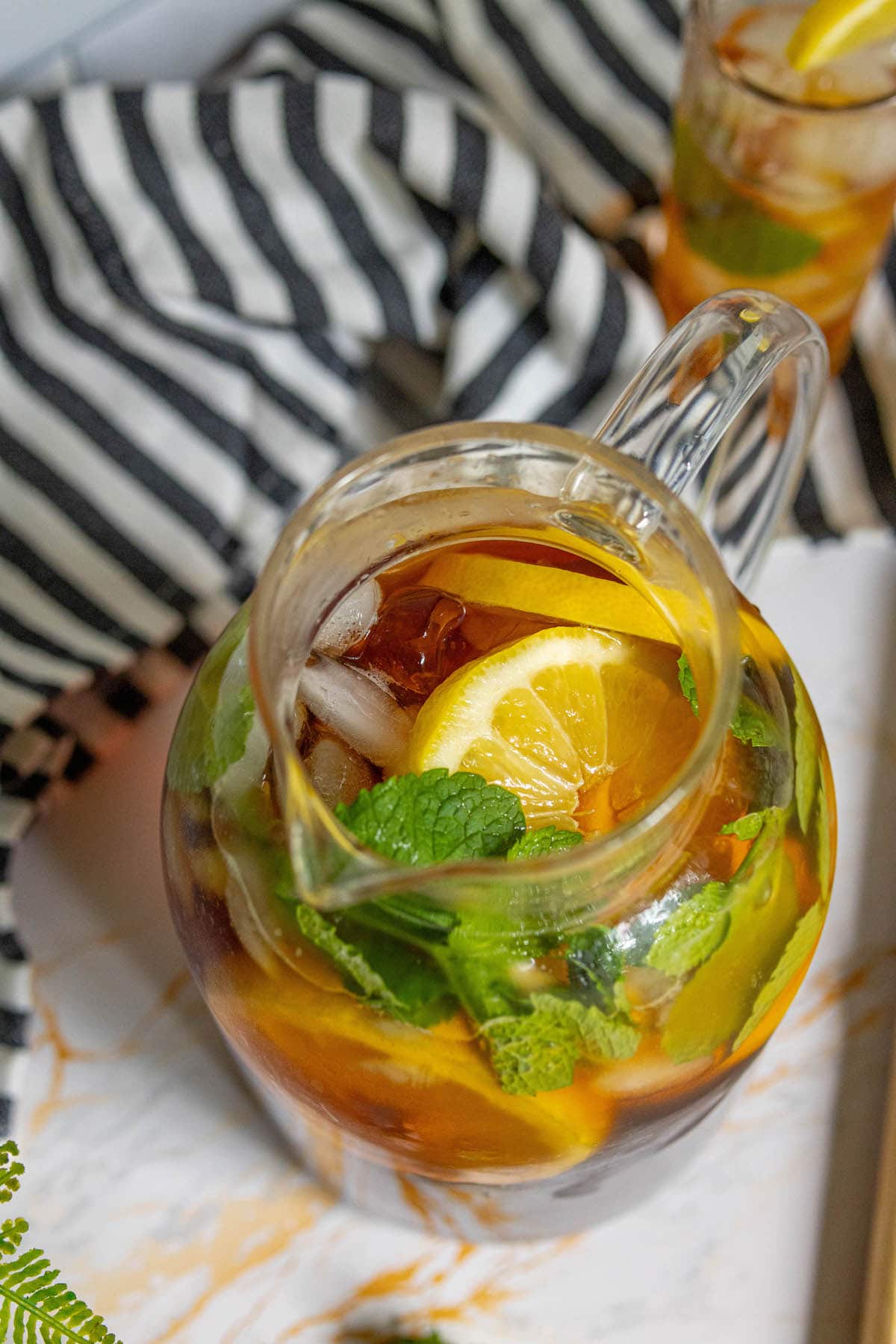 picture of tea in a pitcher with sliced lemons, mint, and ice