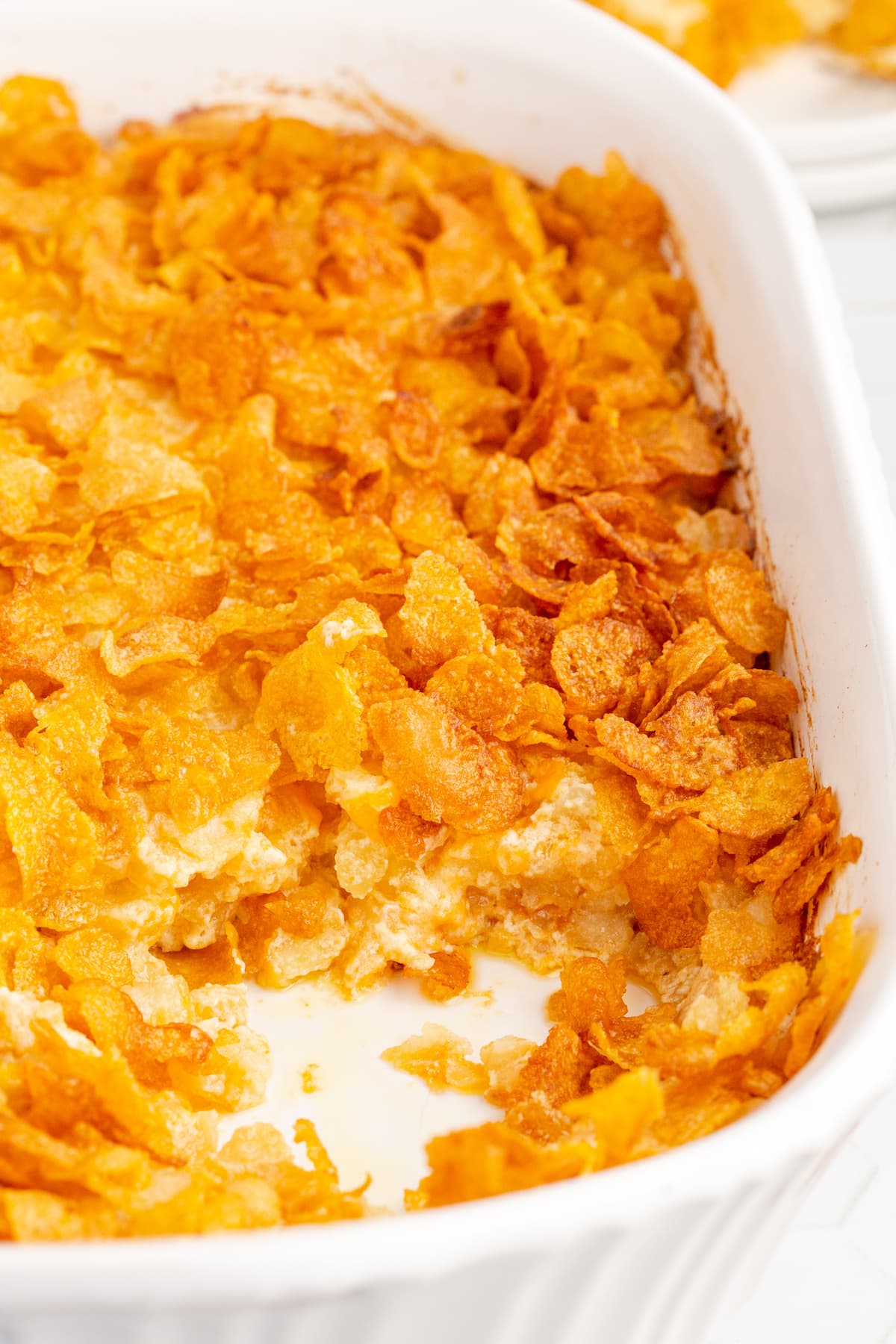 cheesy baked hashbrown casserole topped with cornflakes in a casserole dish