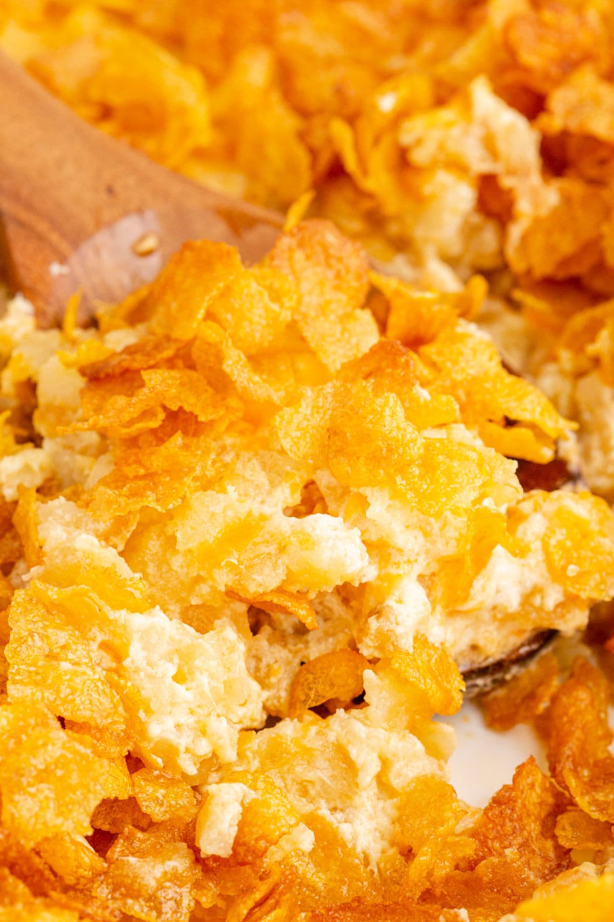 cheesy baked hashbrown casserole topped with cornflakes in a casserole dish