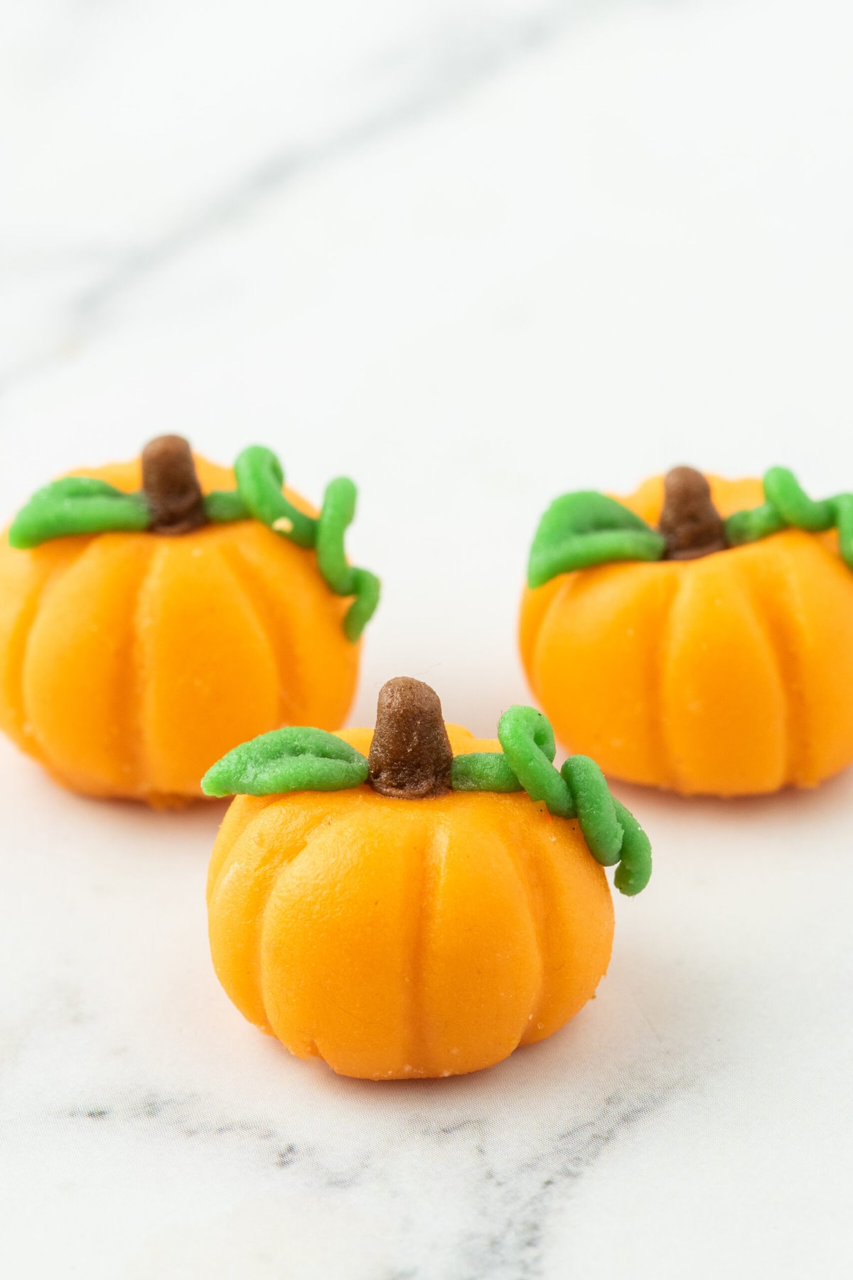 marzipan pumpkin with stem and leaf on a table