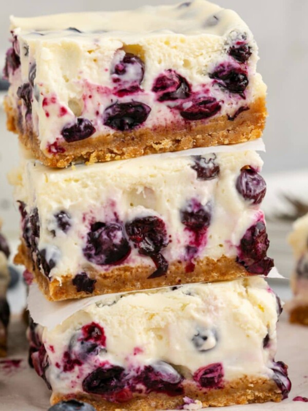 blueberry cheesecake bars stacked on top of each other on a table