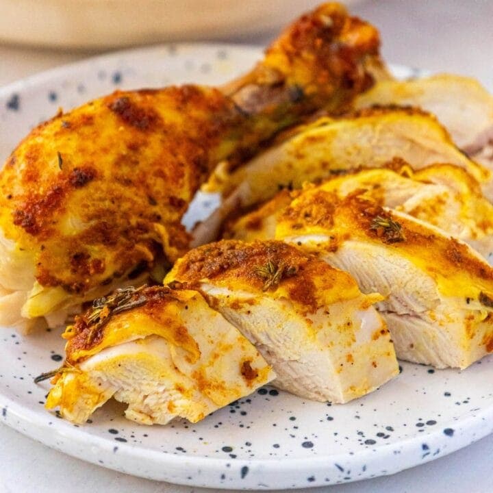 sliced whole roasted chicken with turmeric and garlic on a plate