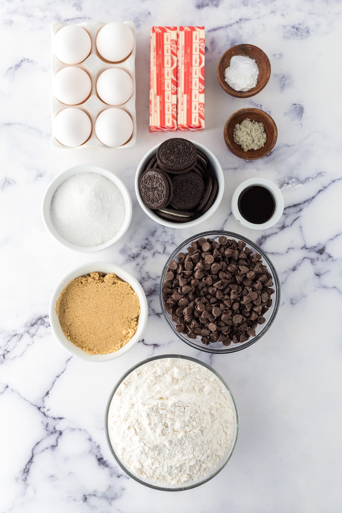 Easy recipe for baked cookie bars stuffed with Oreos on a marble table.