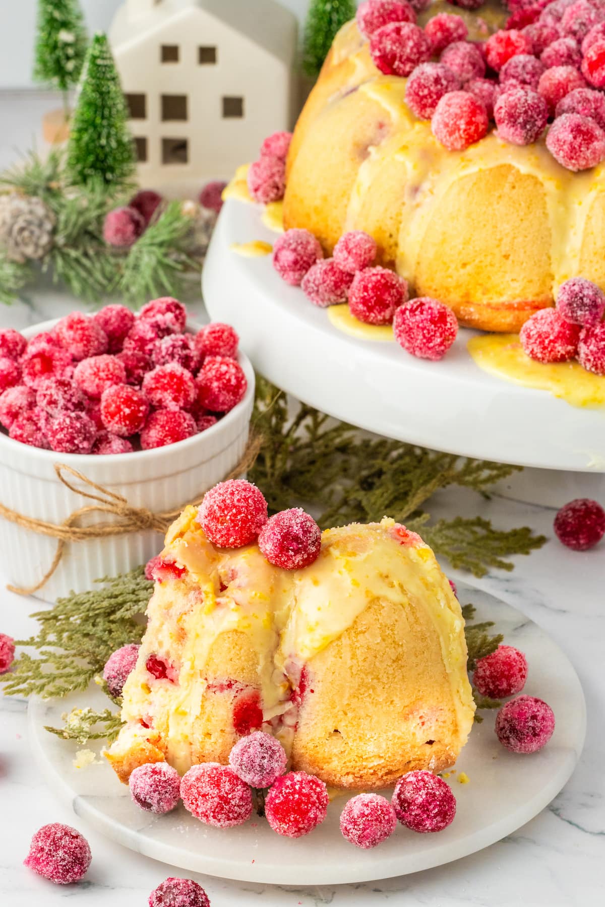 orange cake with candied cranberries on it and some on the side