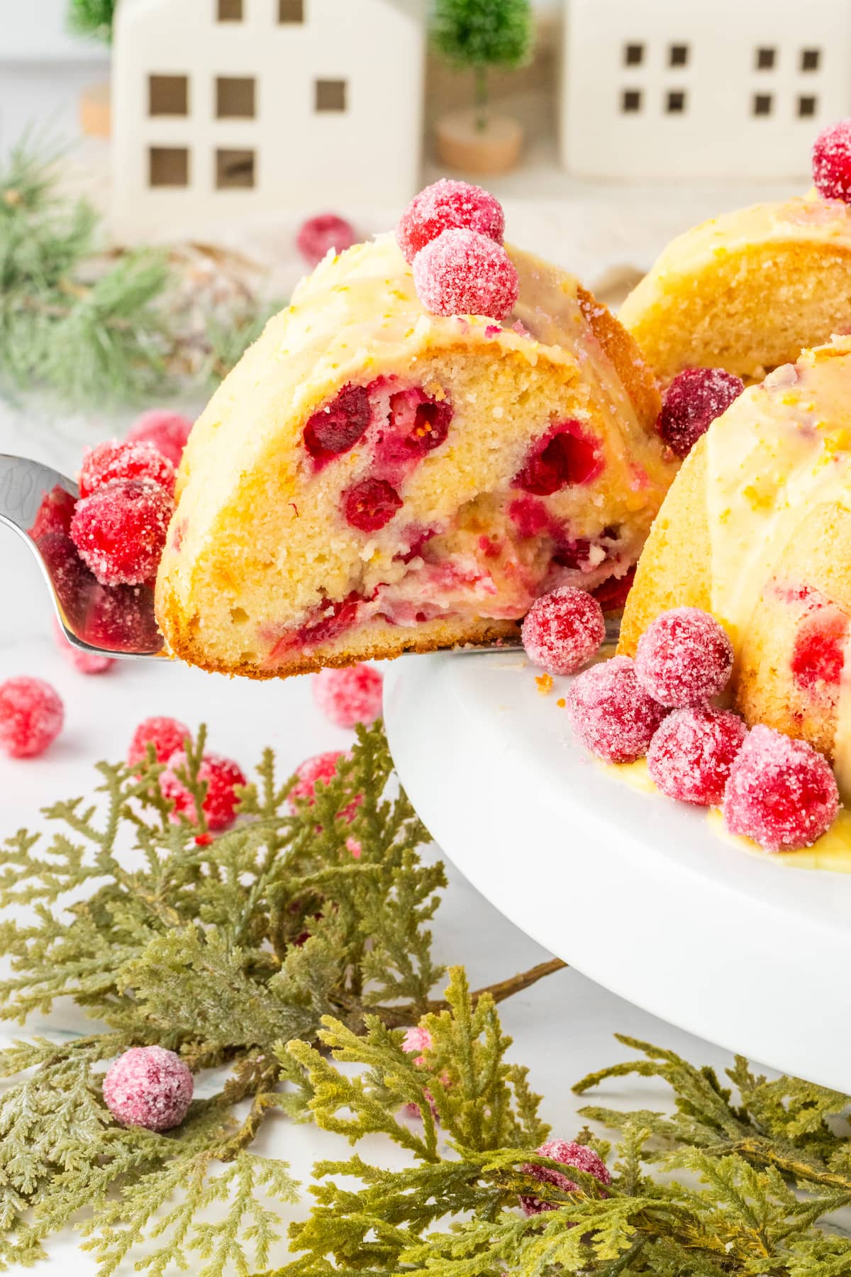 sliced orange cake with candied cranberries on it and some on the side