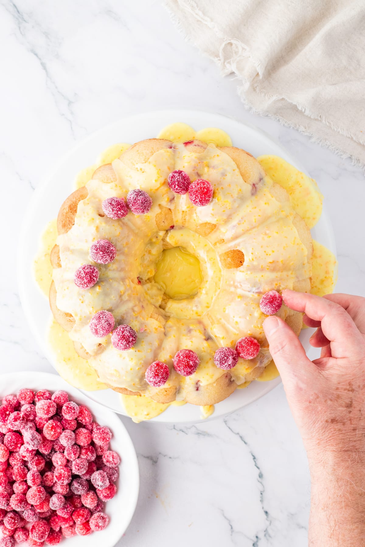 orange cake with candied cranberries on it and some on the side