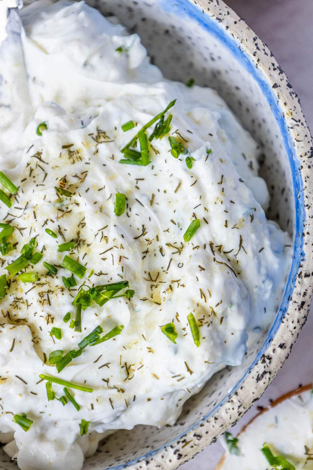 dill schmear in a bowl with chopped chives and pickle seasoning sprinkled on top