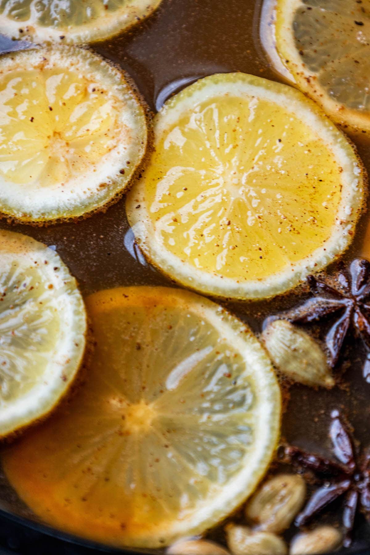 a crock pot with cider, cinnamon sticks, star of anise, and cardamom pods