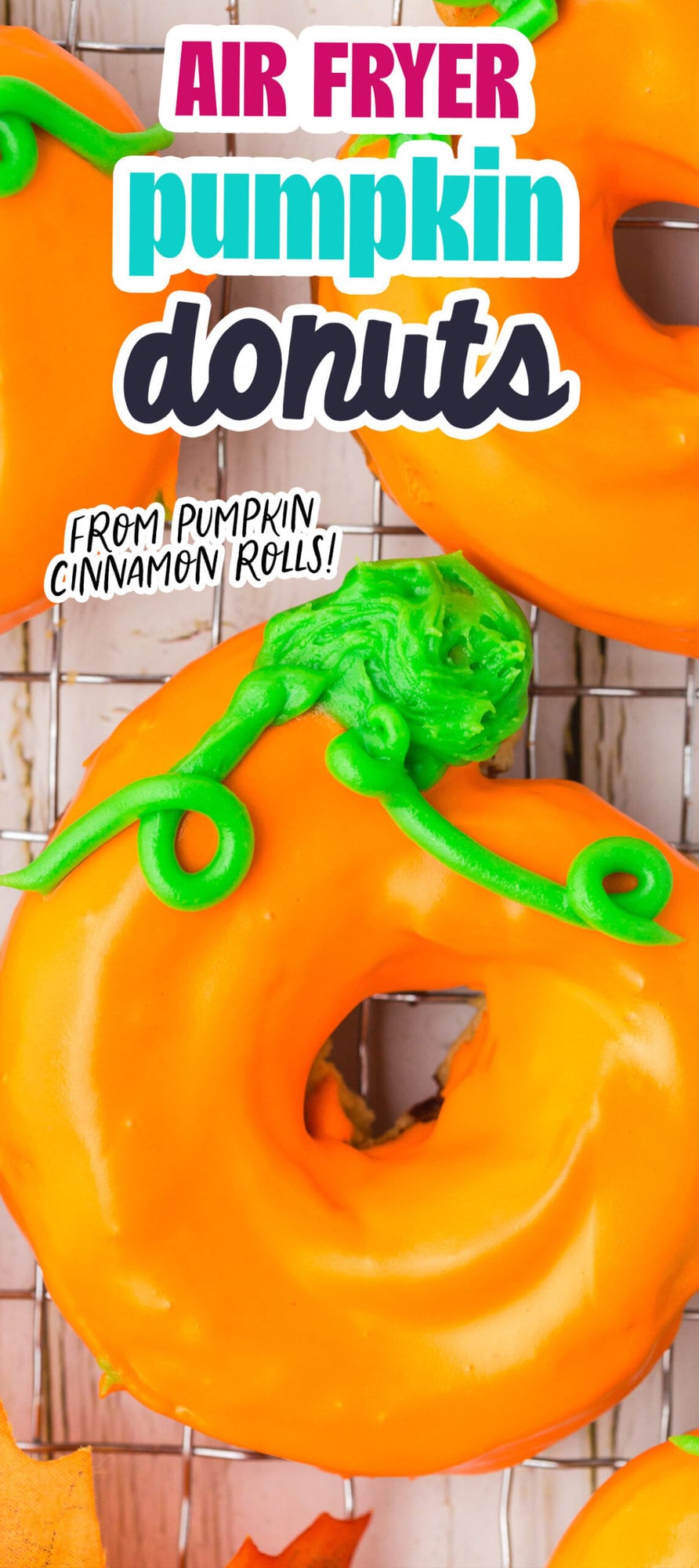 donuts glazed in orange frosting with green leaves and tendrils on top to look like a pumpkin