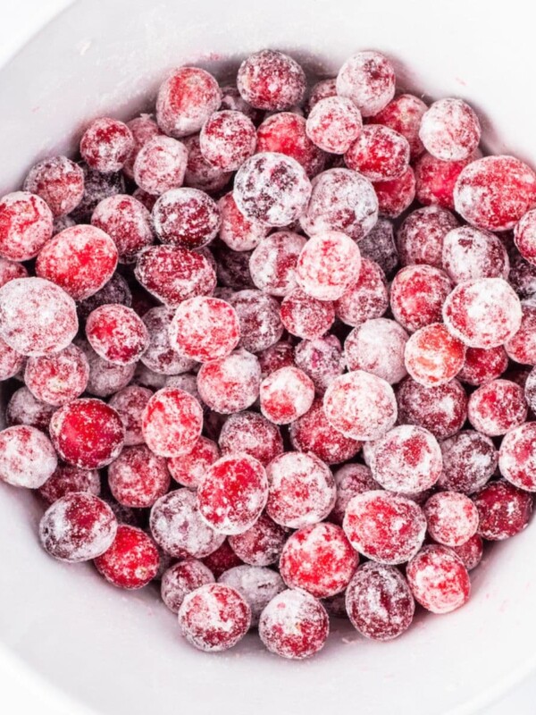 Frozen candied cranberries in a white bowl.