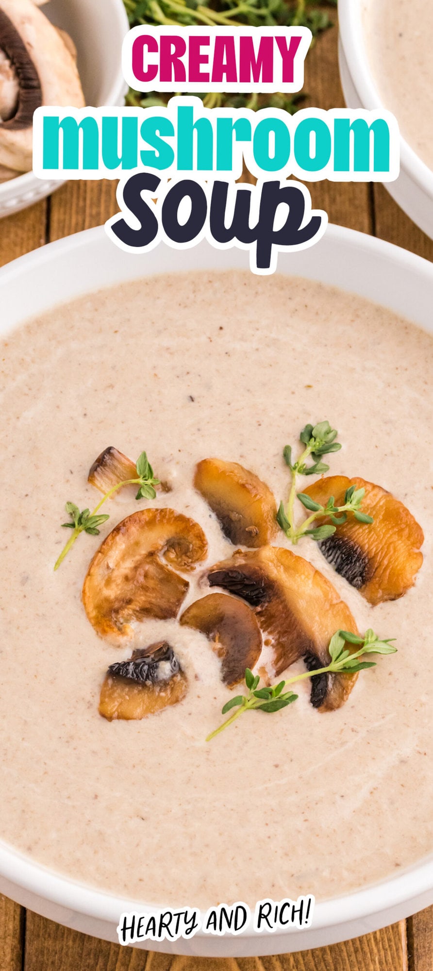 a spoon with mushroom soup and roasted mushrooms on it in a bowl of mushroom soup topped with fresh thyme