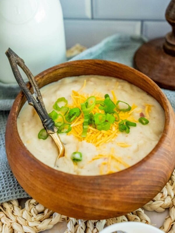 bowl of creamy soup with cheese and green onions on it