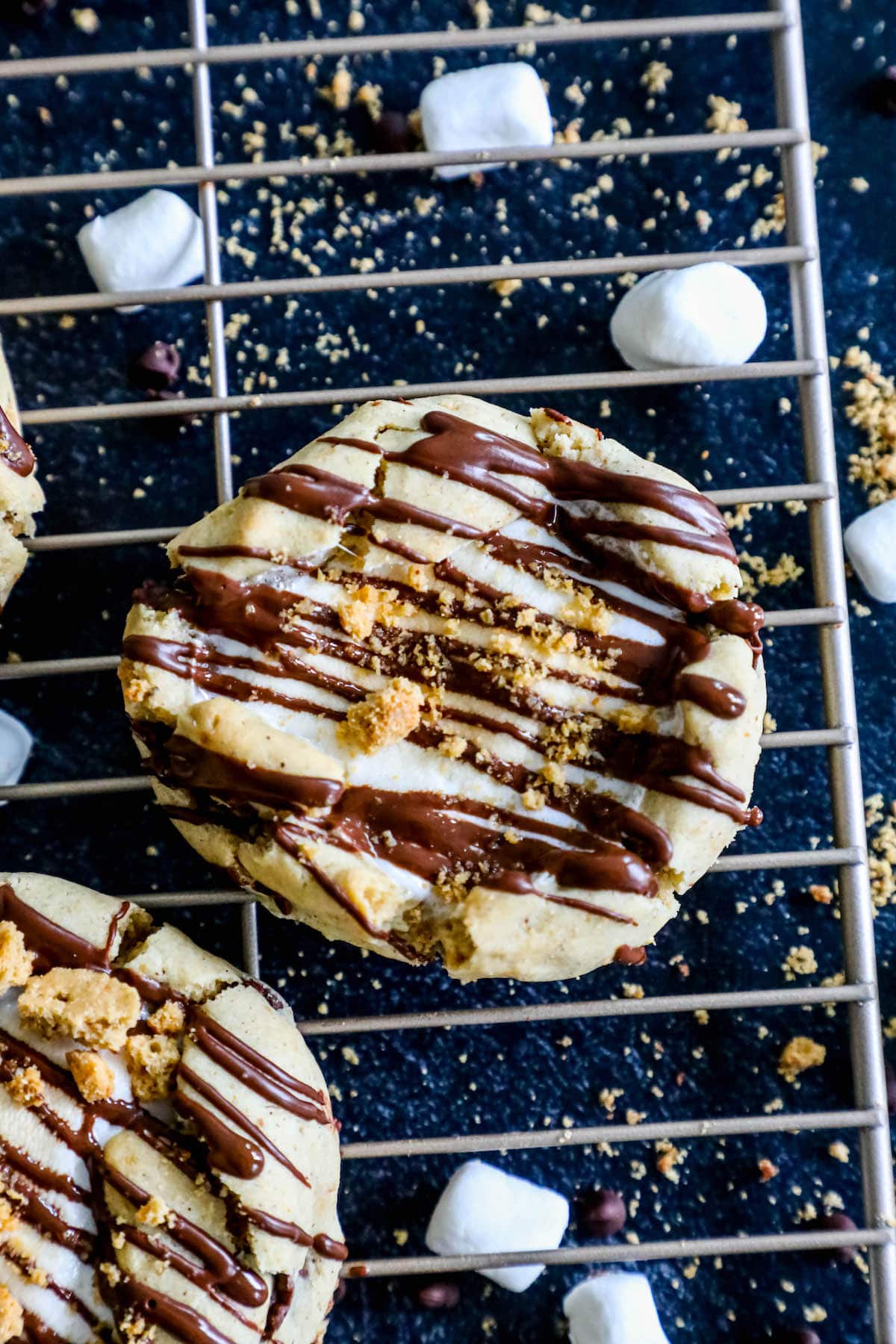 gluten free cookies topped with melted marshmallow, chocolate, and crumbled graham crackers on a cooling rack