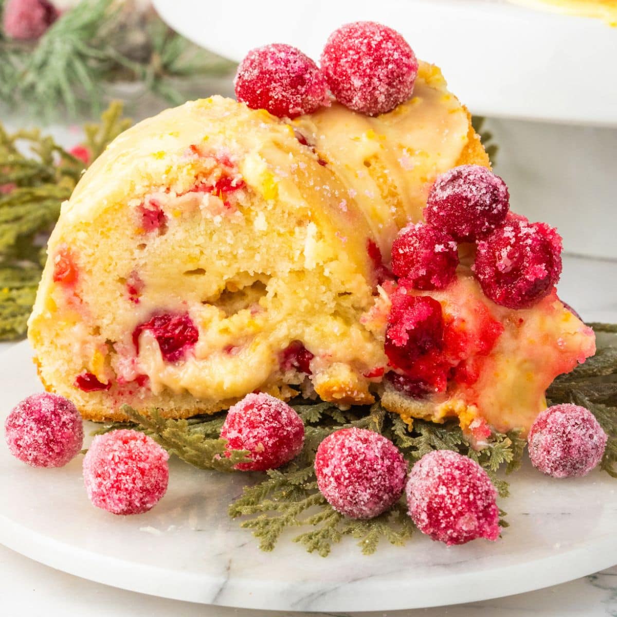 A slice of Cranberry Orange Bundt Cake on a white plate.