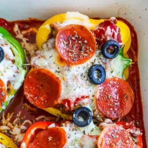 Pepperoni stuffed bell peppers baked in a dish.