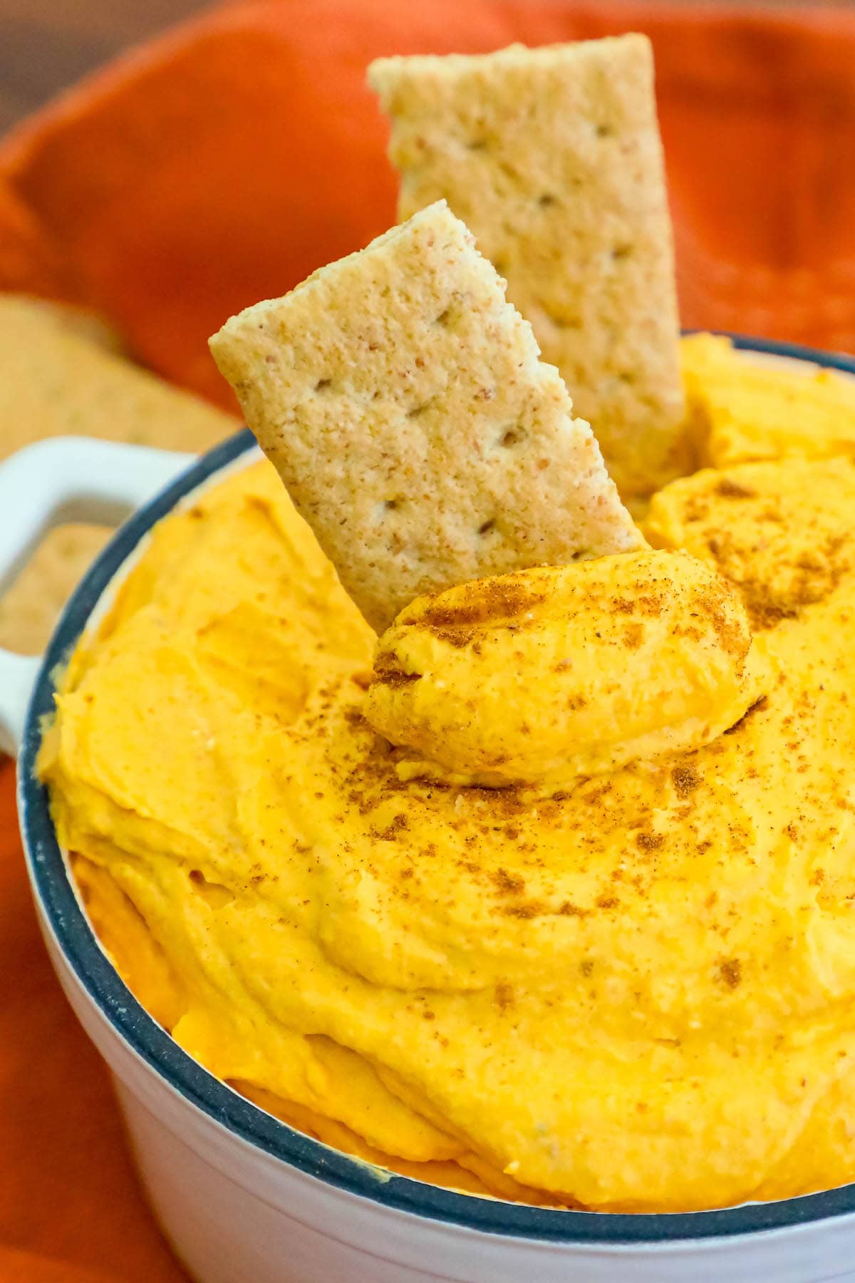 cool whip pumpkin pie fluff in a white bowl with graham crackers in it