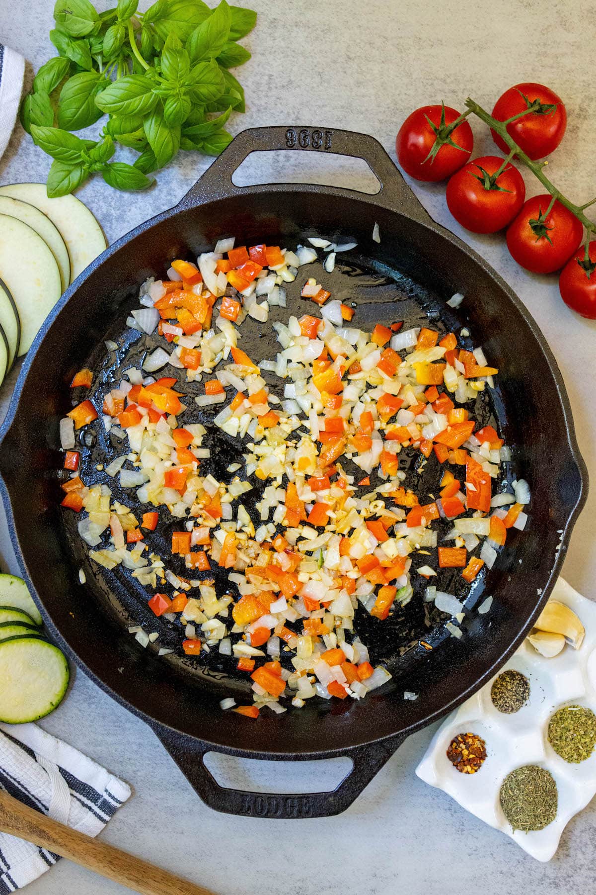 A cast iron skillet filled with vegetables and herbs, creating a delicious and easy ratatouille.