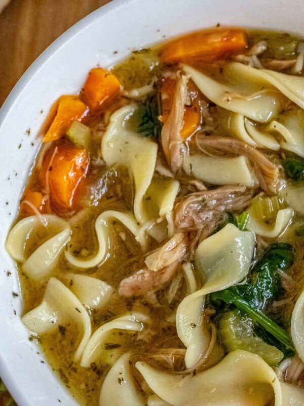 Slow cooker chicken noodle soup in a white bowl.
