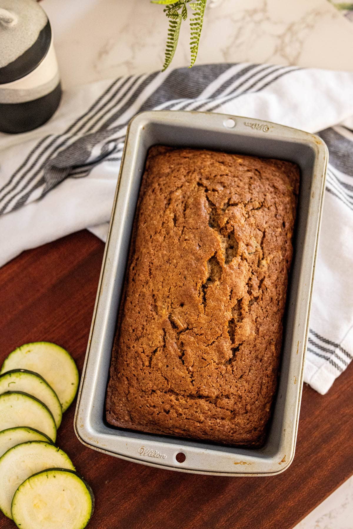 baked zucchini bread slices stacked on top of each other on a cutting board