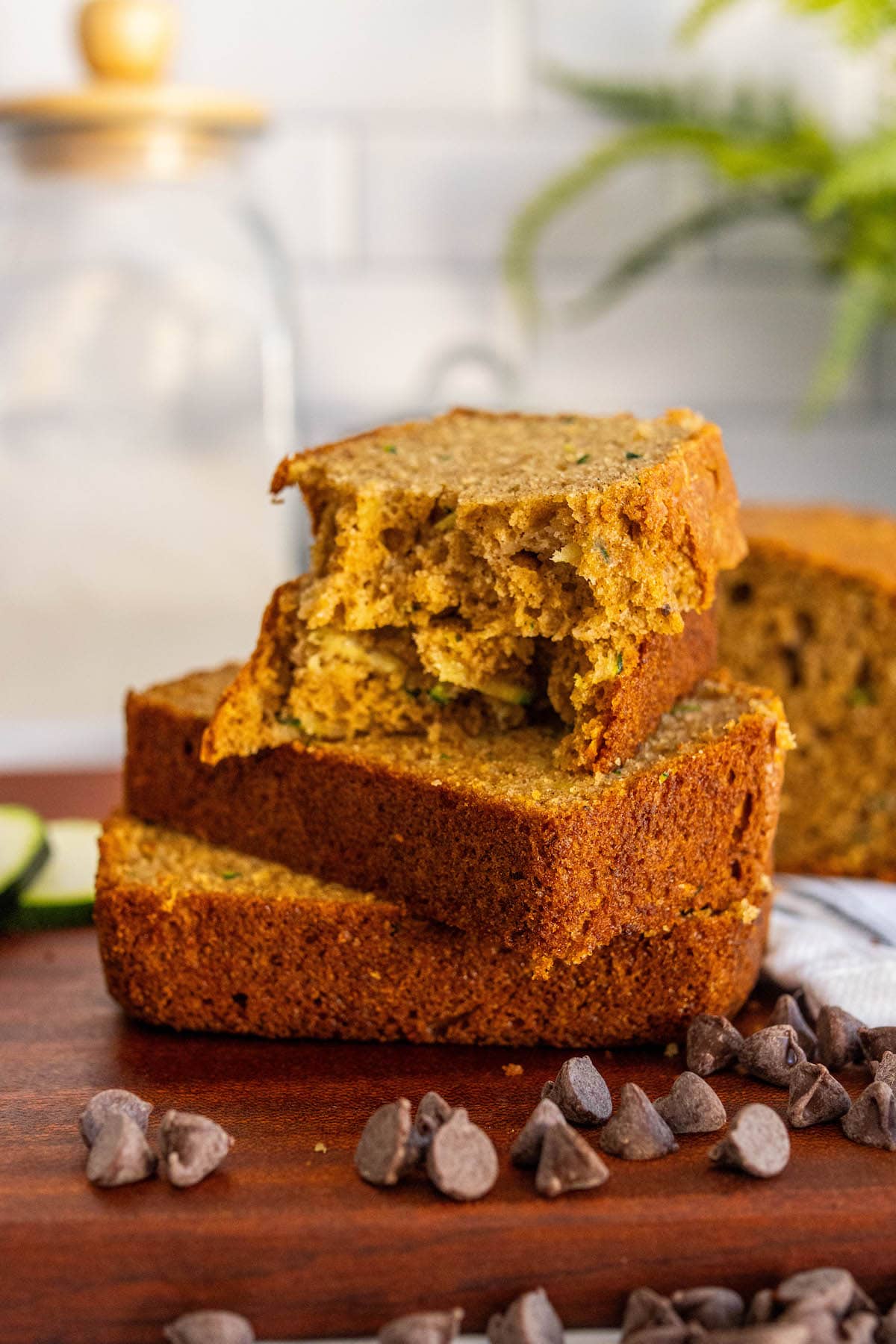 baked zucchini bread slices stacked on top of each other on a cutting board