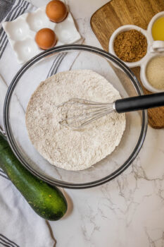 dry flour and cinnamon in a bowl with a whisk in it
