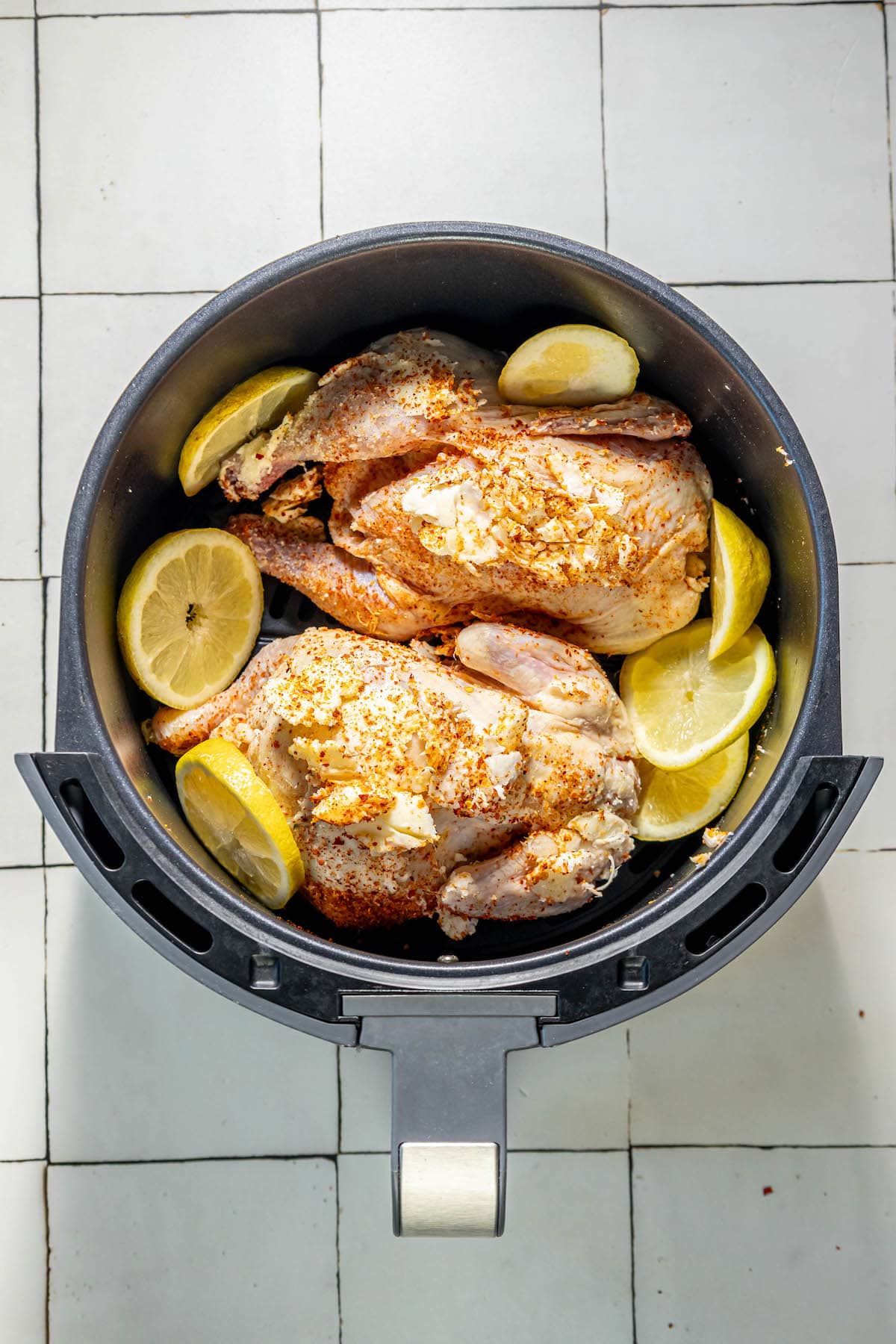 chickens in an air fryer with lemons
