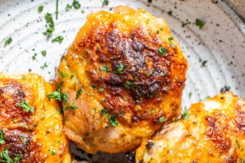 Grilled chicken breasts on a plate with parsley, baked ranch chicken.