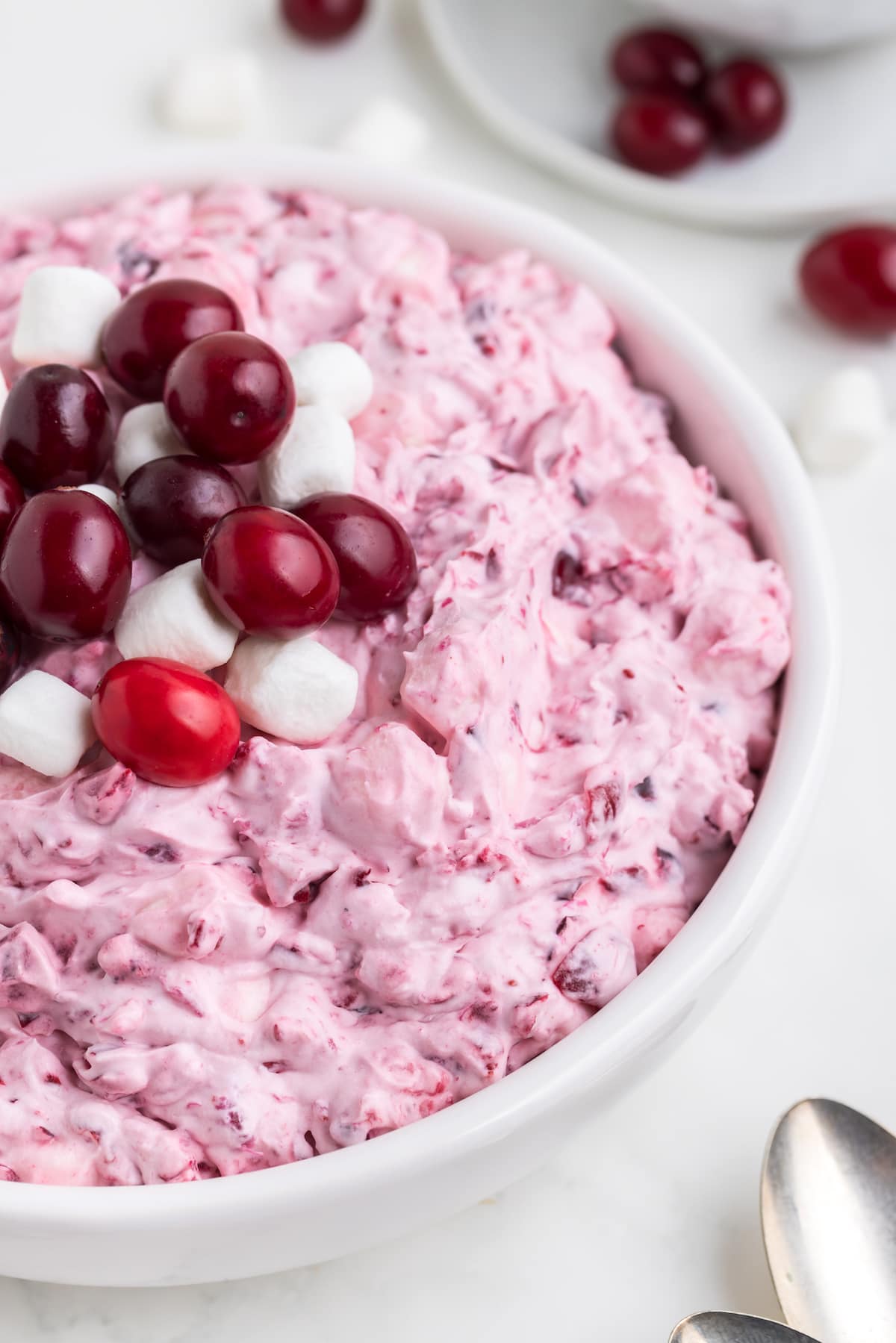 cranberry fluff with marshmallows in a white bowl with cranberries and marshmallows on top